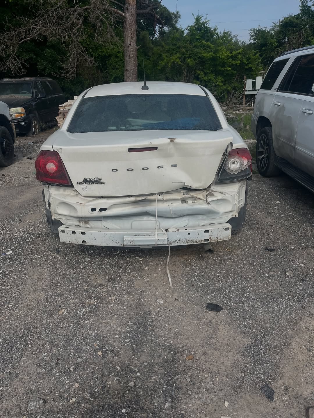 Dodge Avenger before repair — rear trunk and bumper crushed from rear-end collision