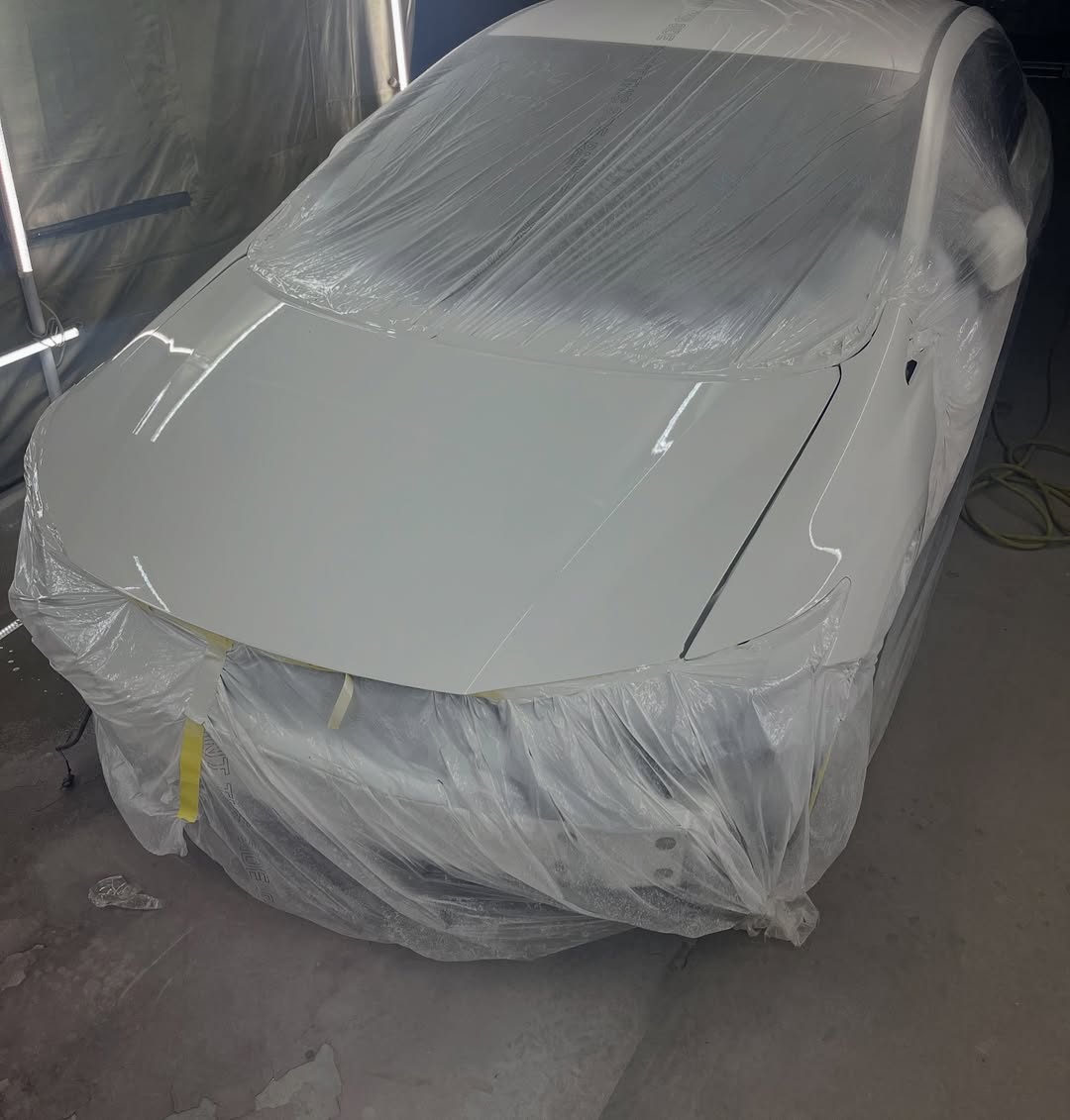 Honda Civic in paint booth — primed and masked for paint application